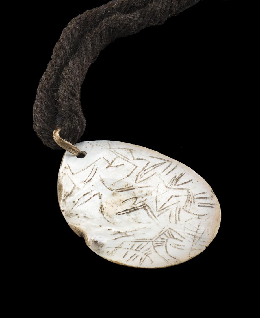 AN EARLY ENGRAVED PEARL SHELL PENDANT