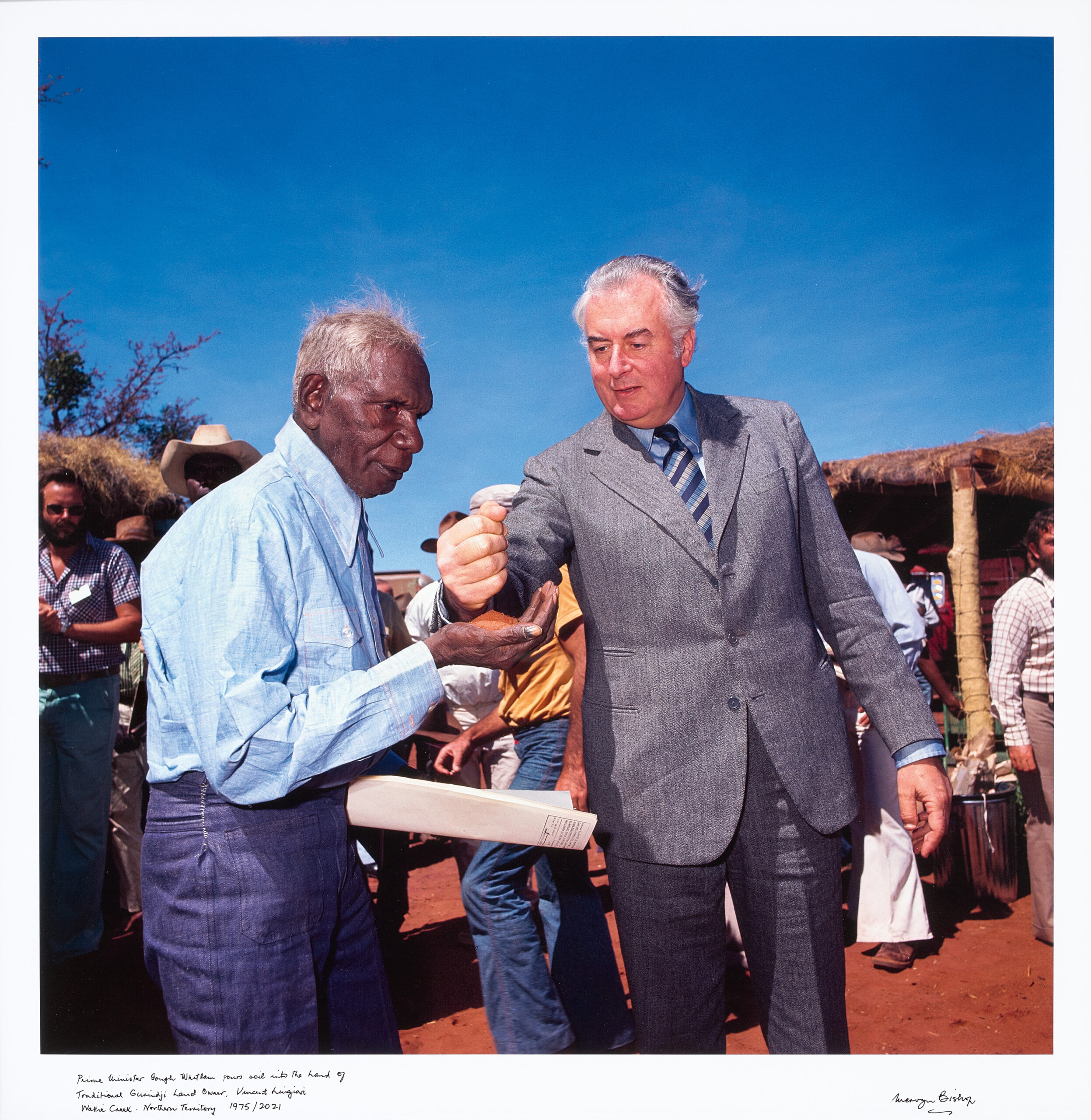 PRIME MINISTER GOUGH WHITLAM POURS SOIL INTO THE HANDS OF TRADITIONAL LANDOWNER
