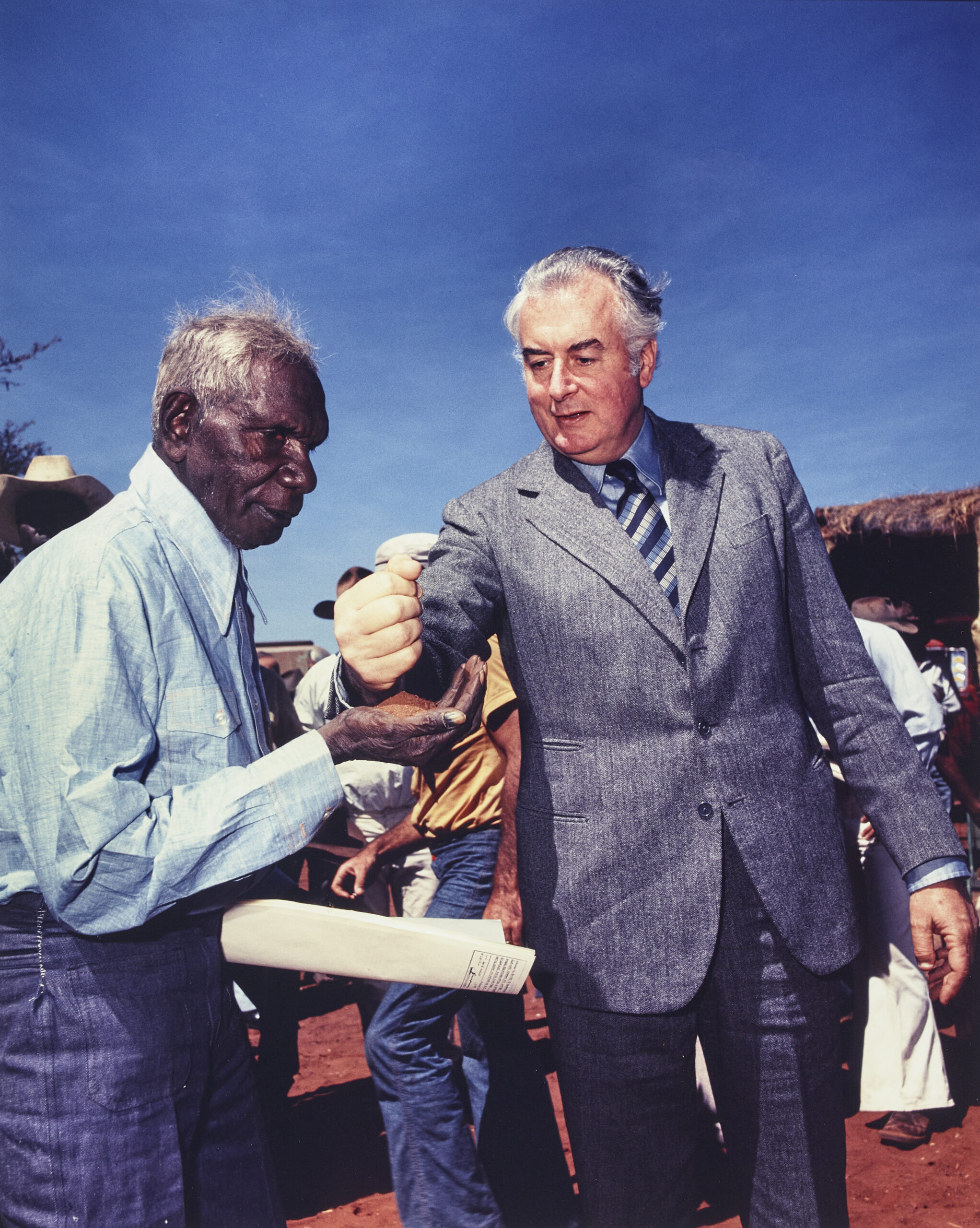 PRIME MINISTER GOUGH WHITLAM POURS SOIL INTO THE HANDS OF TRADITIONAL LANDOWNER VINCENT LINGIARI, NORTHERN TERRITORY
